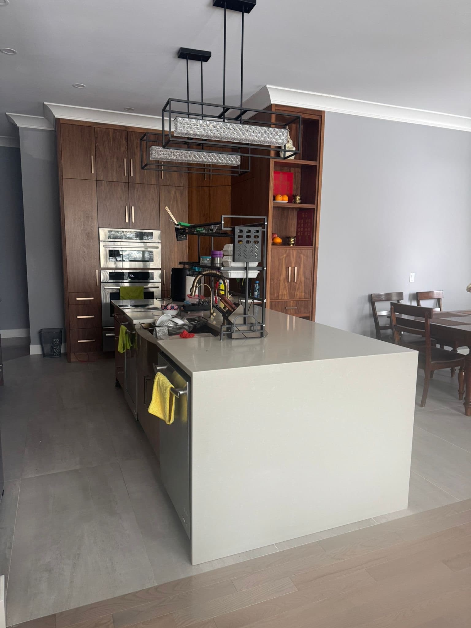 Contemporary kitchen with dark wood custom cabinets, large island, and modern pendant lights by Calgary custom cabinets.