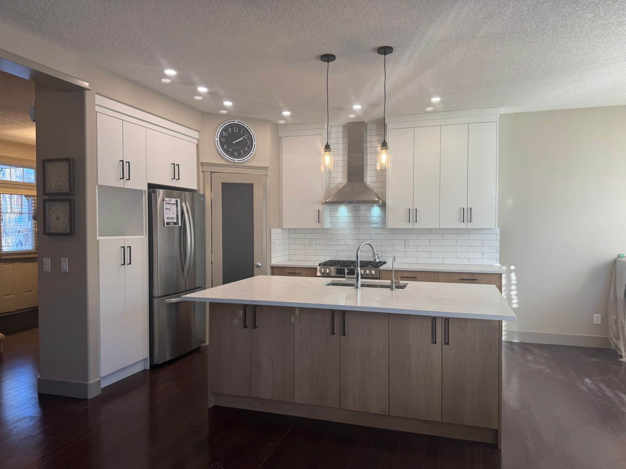 Custom white kitchen cabinets with glass upper doors and crown molding by YYC Cabinets Calgary