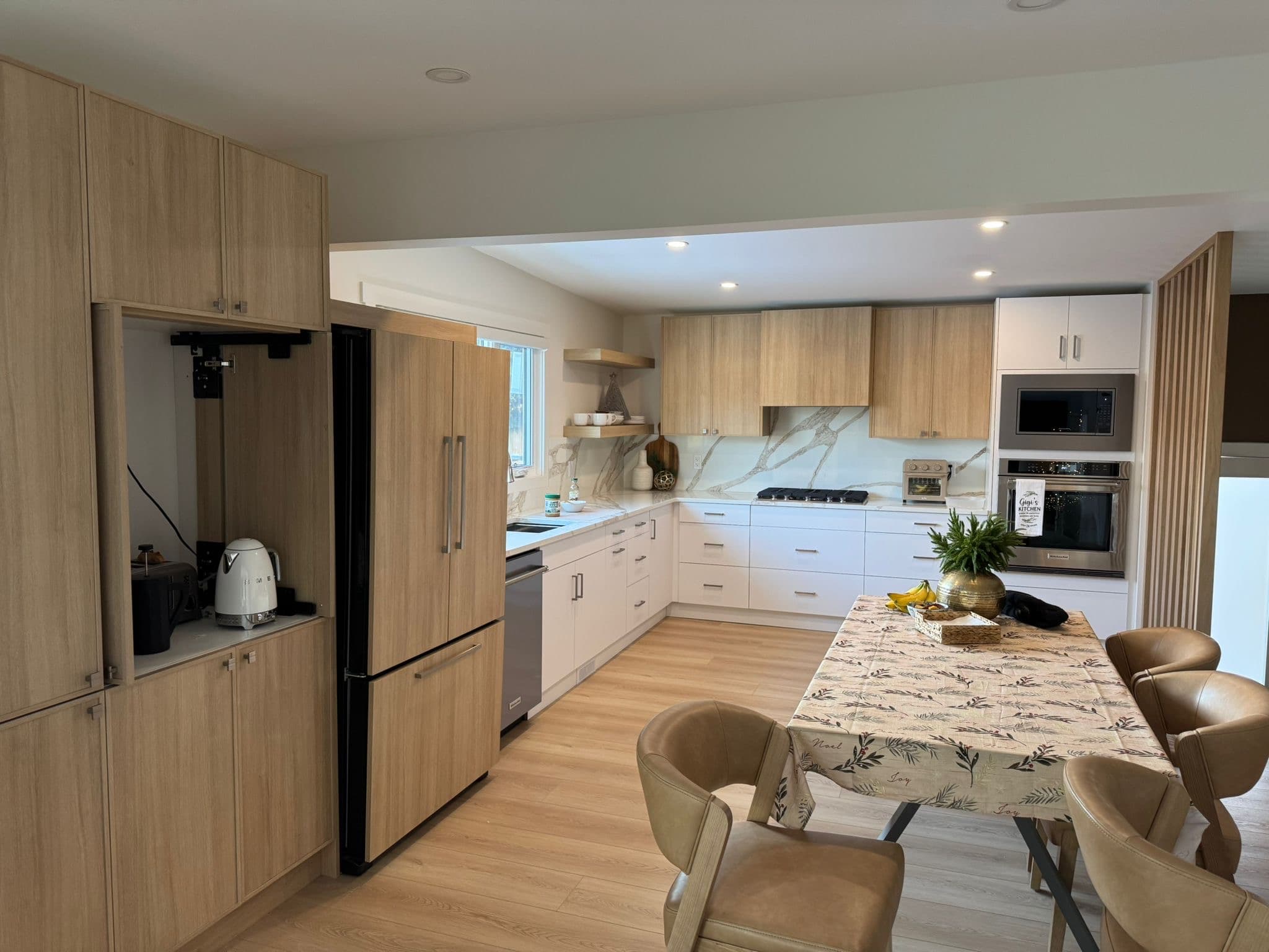 Bright white custom kitchen cabinets with quartz countertops and stainless steel appliances by YYC Cabinets Calgary