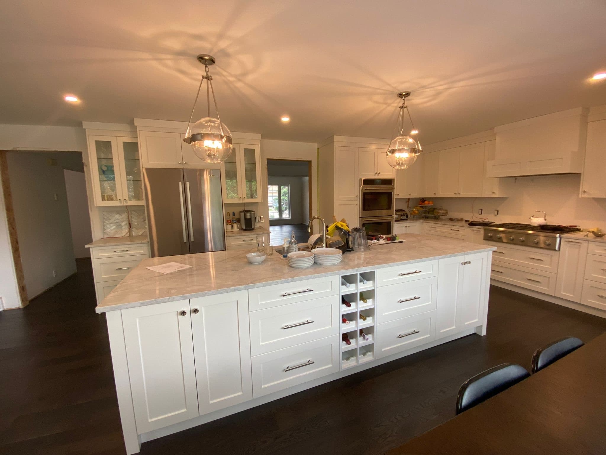 Spacious white kitchen with large island, marble countertops, and custom white cabinetry, a prime example of Calgary custom cabinets.
